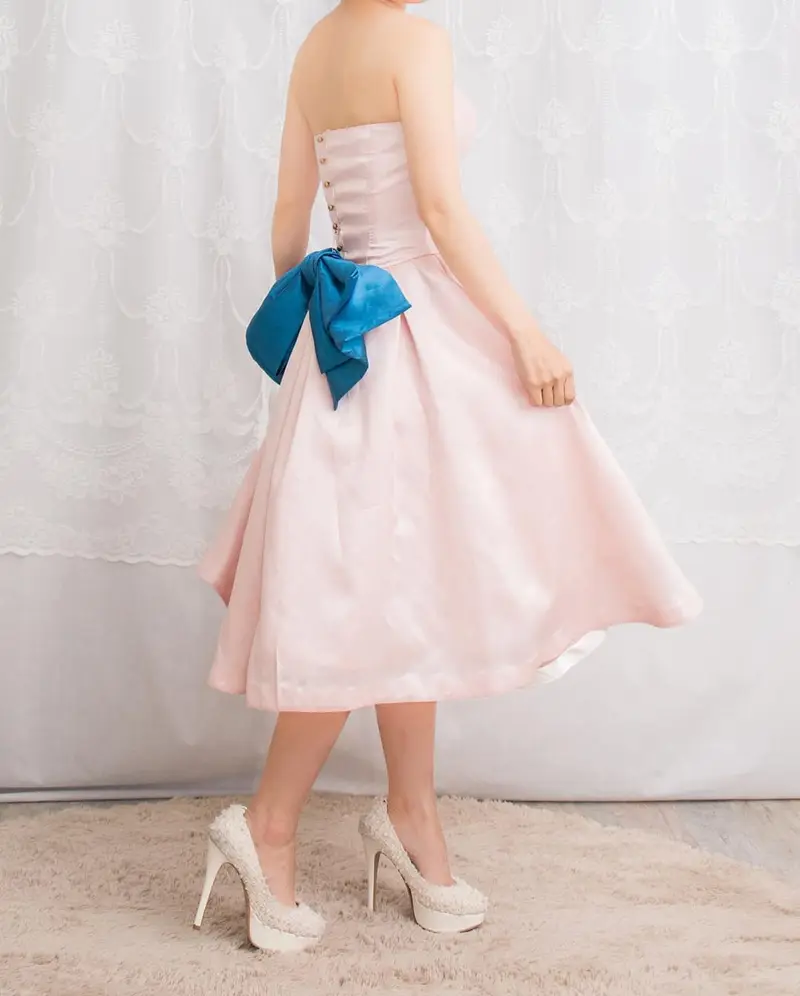ピーチピンクのサテンミディドレスの後ろ姿